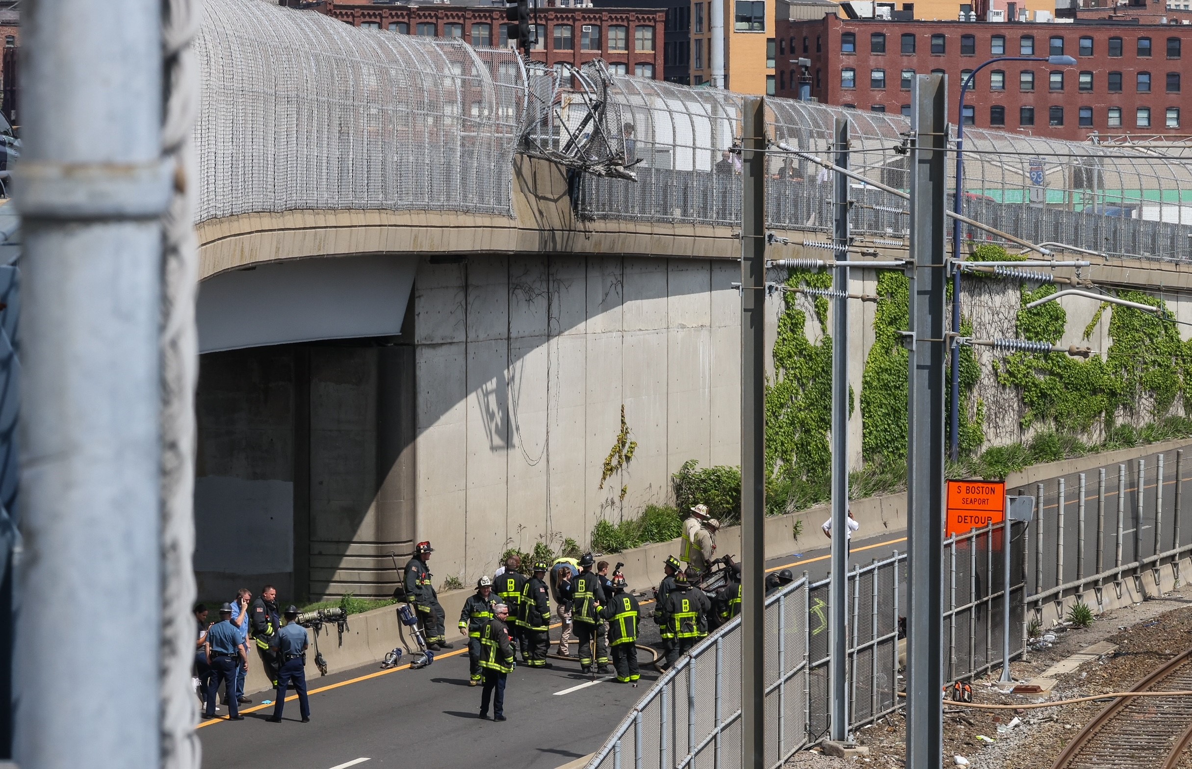 A broken fence above a fiery car wreck in Boston on Wednesday, June 5, 2024.