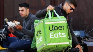 Uber Eats workers wait for orders in central Kiev, Ukraine July 31, 2019.