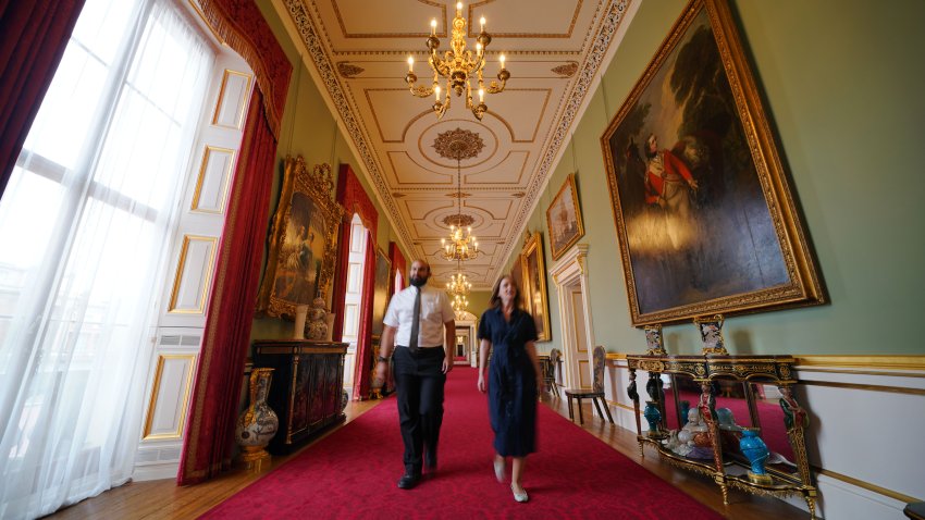 Members of Royal Collection Trust staff walk through the Principal Corridor in the East Wing of Buckingham Palace