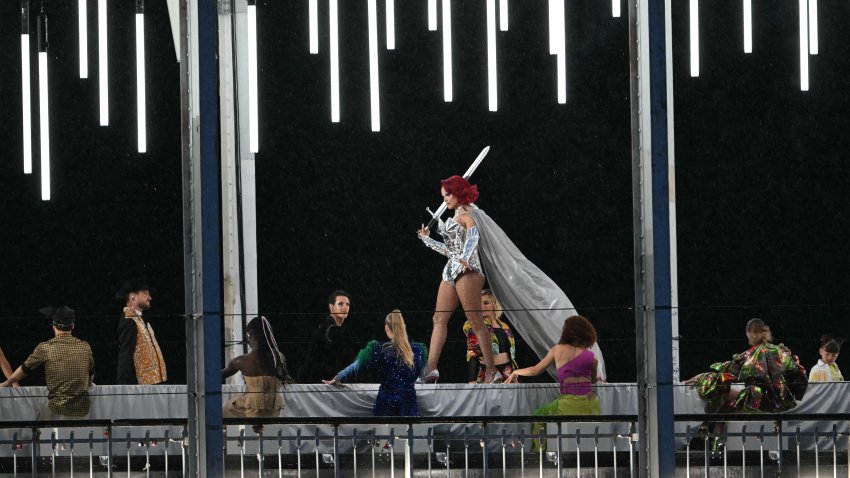 A model presents creations while walking a catwalk erected along the Passerelle Debilly bridge on the Seine river during the opening ceremony of the Paris 2024 Olympic Games in Paris on July 26, 2024. (Photo by Mauro PIMENTEL / AFP) (Photo by MAURO PIMENTEL/AFP via Getty Images)