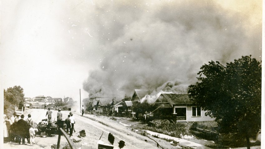 A group of people looking at smoke in the distance coming from damaged properties following the Tulsa Race Massacre, Tulsa, Oklahoma, June 1921.