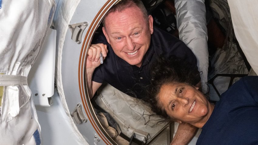 NASA astronauts Butch Wilmore, left, and Suni Williams pose inside the hatch connecting Boeing’s Starliner to the International Space Station