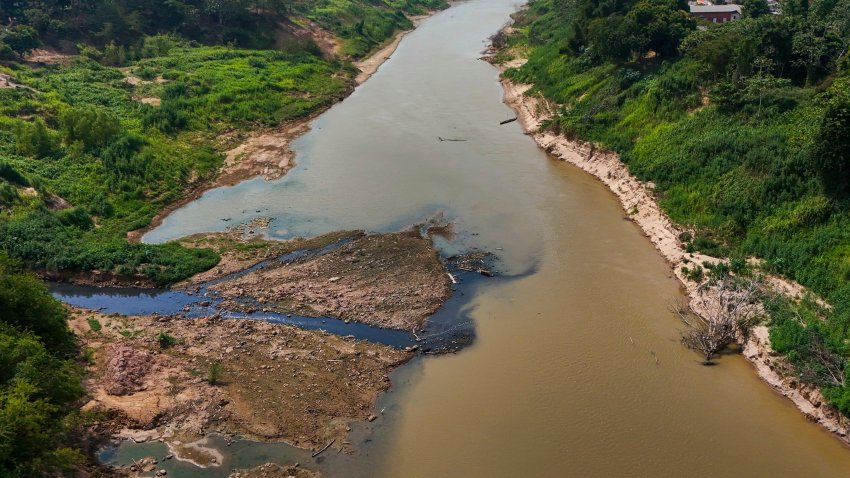 Blackwater, left, pollutes the Acre River near Rio Branco, Acre state, Brazil, Friday, Aug. 2, 2024. The city of Rio Branco faces water shortages due to the river’s low levels amid a drought.