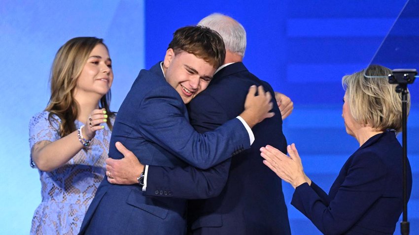 Democratic vice presidential nominee Tim Walz embraces his son Gus (2L) as daughter Hope (L) and wife Gwen Walz (R) look on after the governor's DNC speech at the United Center in Chicago on Aug. 21, 2024.