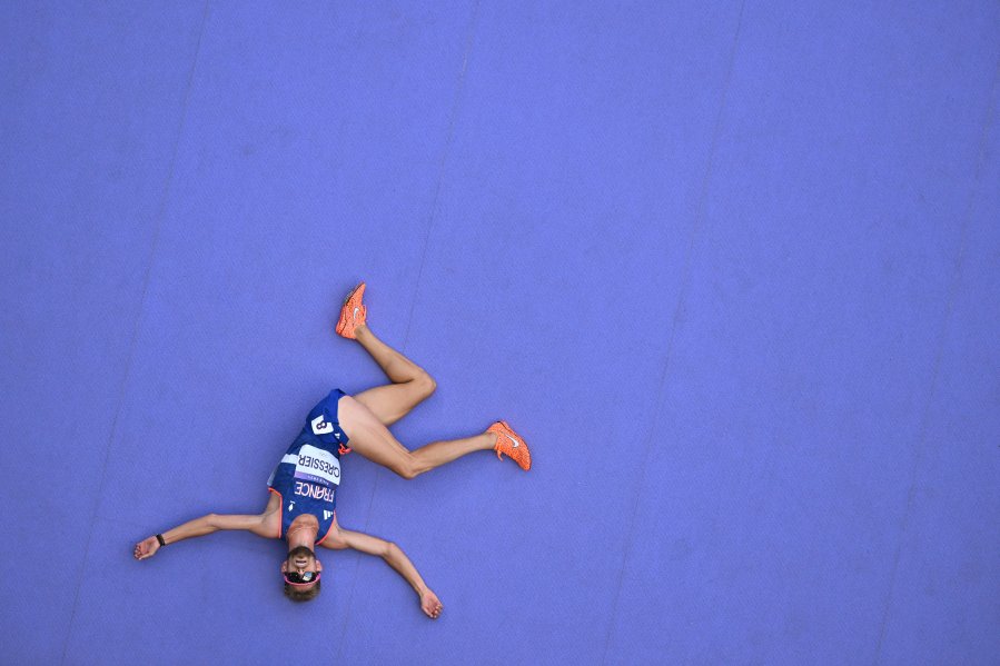 An overview shows France's Jimmy Gressier reacting after competing in the men's 5000m heat of the athletics event at the Paris 2024 Olympic Games at Stade de France in Saint-Denis, north of Paris, on August 7, 2024