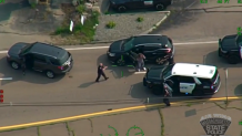 In this image taken from a state police aircraft, Matthew Paluzzi is detained at gunpoint on Thursday, Aug. 15, 2024, by police in Hanover assisting with the investigation into the killing of his father in Plymouth, Massachusetts.