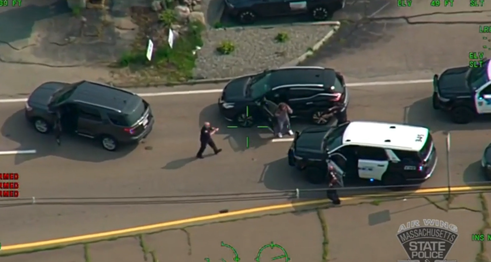 In this image taken from a state police aircraft, Matthew Paluzzi is detained at gunpoint on Thursday, Aug. 15, 2024, by police in Hanover assisting with the investigation into the killing of his father in Plymouth, Massachusetts.