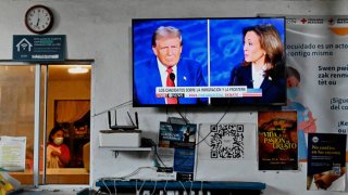 The first debate between Vice President Kamala Harris and former President Donald Trump is shown on television at the Juventud 2000 migrant shelter in Tijuana, Mexico, on Sept. 10, 2024. Immigration has been a hot topic throughout the presidential campaign.