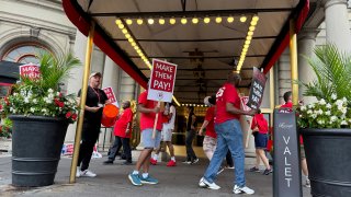 Hotel workers on strike chant and beat drums