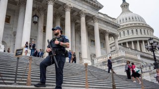 A U.S. Capitol Police officer stands watch as lawmakers leave the House of Representatives after voting on an interim spending bill to avoid a government shutdown next week, at the Capitol in Washington, Wednesday, Sept. 25, 2024.