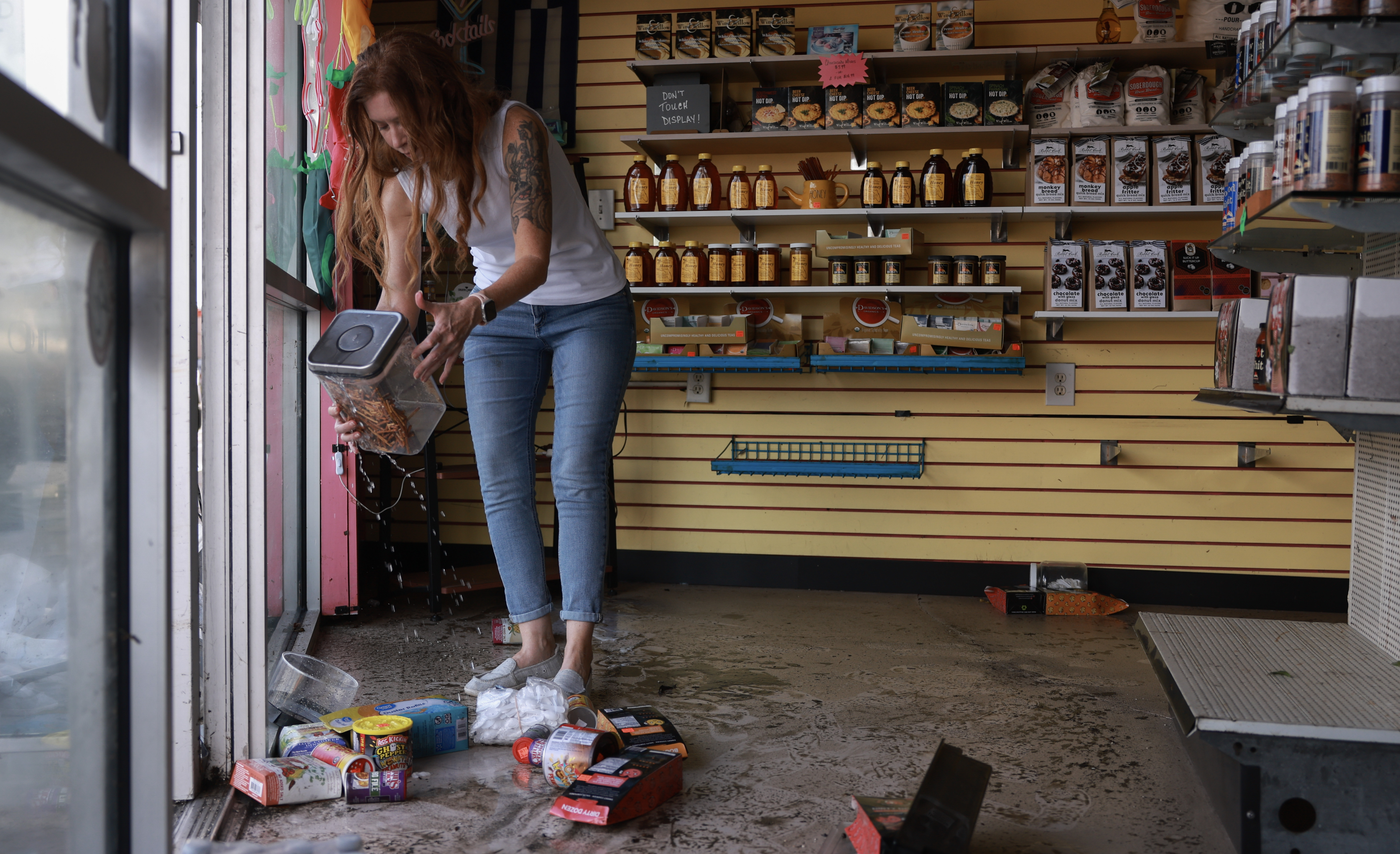 Candace Redwine surveys the damage after about 3 feet of water inundated her Spiceman Kitchen store when Hurricane Helene passed offshore on September 27, 2024 in Tarpon Springs, Florida.