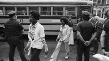 Sept. 12, 1974: As police stand guard, Black students arrive at the predominately all-white South Boston High School on the first day of classes under a federal court-ordered busing program aimed at desegregating the school system.