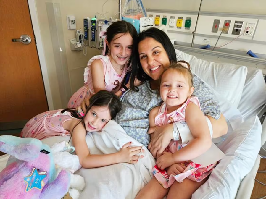 The Lammert girls snuggle up in their mom's hospital bed.