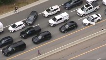 People out of their cars in standstill traffic on the Massachusetts Turnpike west behind an overturned truck on Thursday, Sept. 19, 2024.