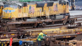 A rail employee works a Union Pacific Intermodal Terminal rail yard on November 21, 2022 in Los Angeles, California.