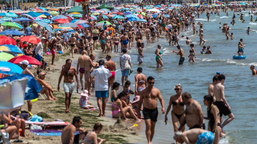 Tourists and locals cool off at a El Postiguet Beach in Alicante, Spain.