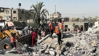 Palestinians check a building destroyed by Israeli airstrikes in the city of Khan Younis, southern Gaza Strip, Friday, Oct. 25, 2024.