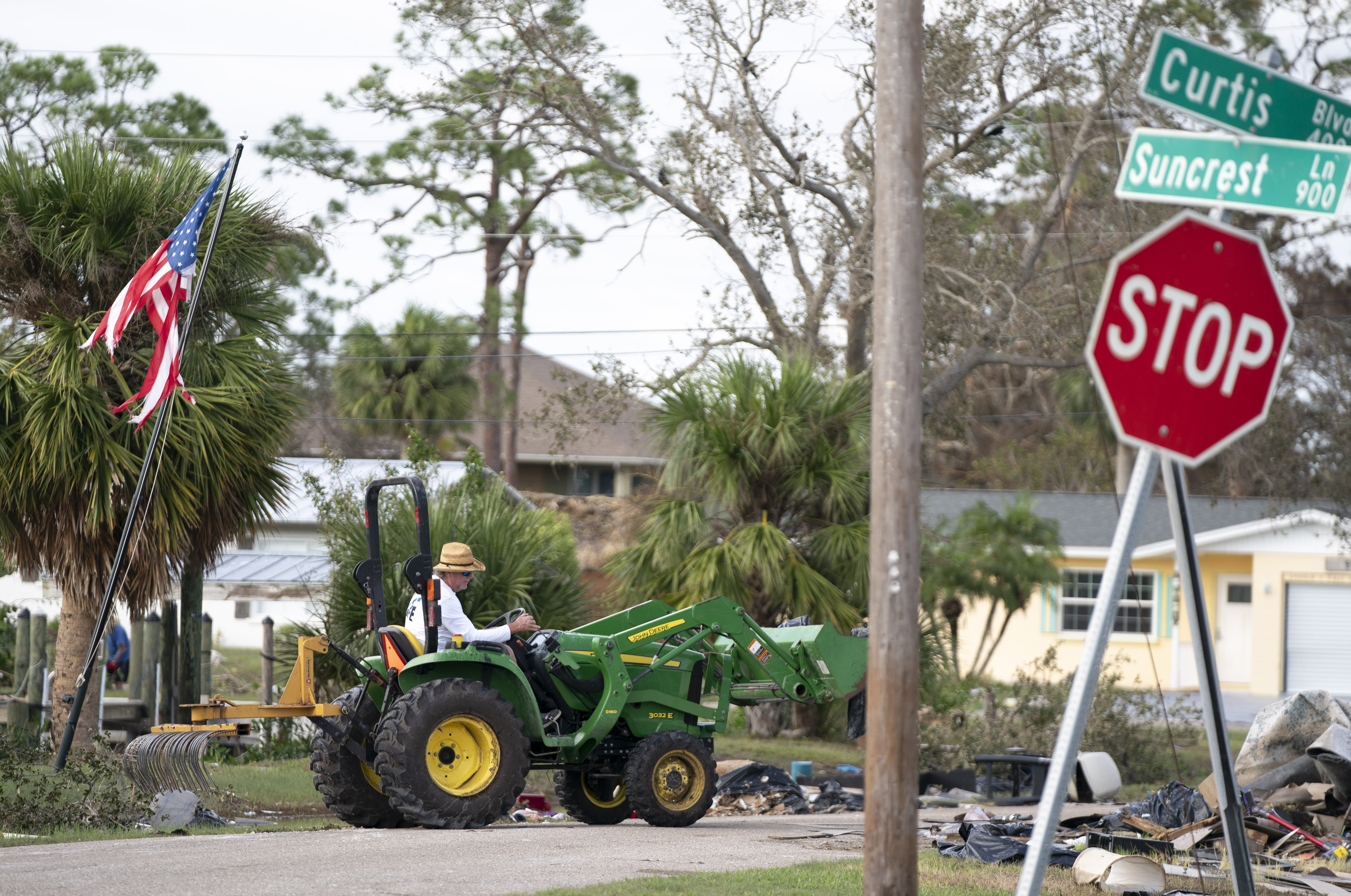 A man cleans storm debris using a tractor in the aftermath of Hurricane Milton on Oct. 10, 2024 in Englewood, Fla.