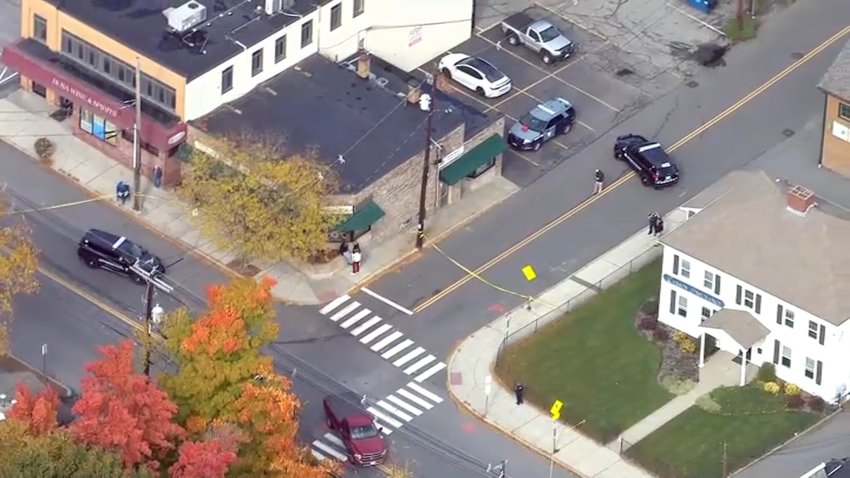 An aerial shot of an intersection, one road blocked off with police tape and a police cruiser.