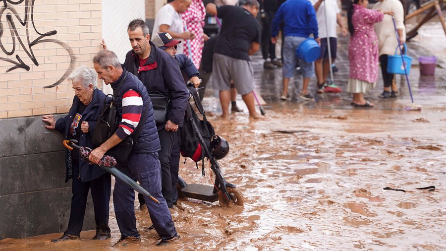 People walk through flooded streets in Valencia, Spain, Wednesday, Oct. 30, 2024.