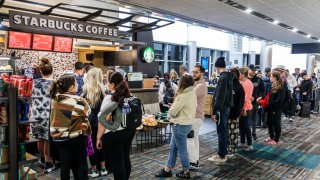 Customers wait in a long line at a Starbucks cafe in a terminal at Miami International Airport, in Miami, Dec. 12, 2022.