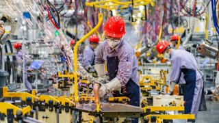 Employees work on the assembly line of an intelligent factory of SERES Automobile Co., Ltd in Chongqing, China on July 19, 2022. 