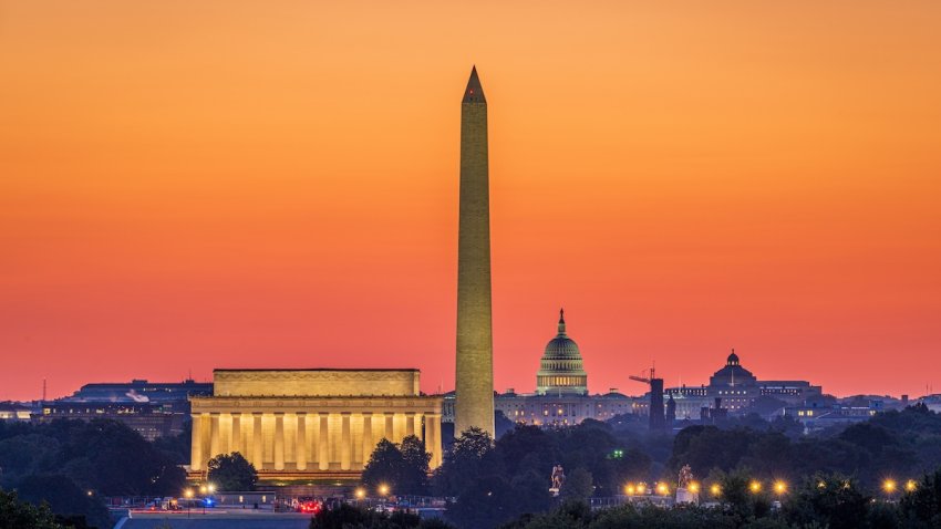 WASHINGTON, DC - SEPTEMBER 10: The rising sun turns the sky orange behind the Washington skyline, including the Lincoln Memorial, left, Washington Monument, center, and the U.S. Capitol Building, right, on September 10, 2024, as seen from Arlington, VA.