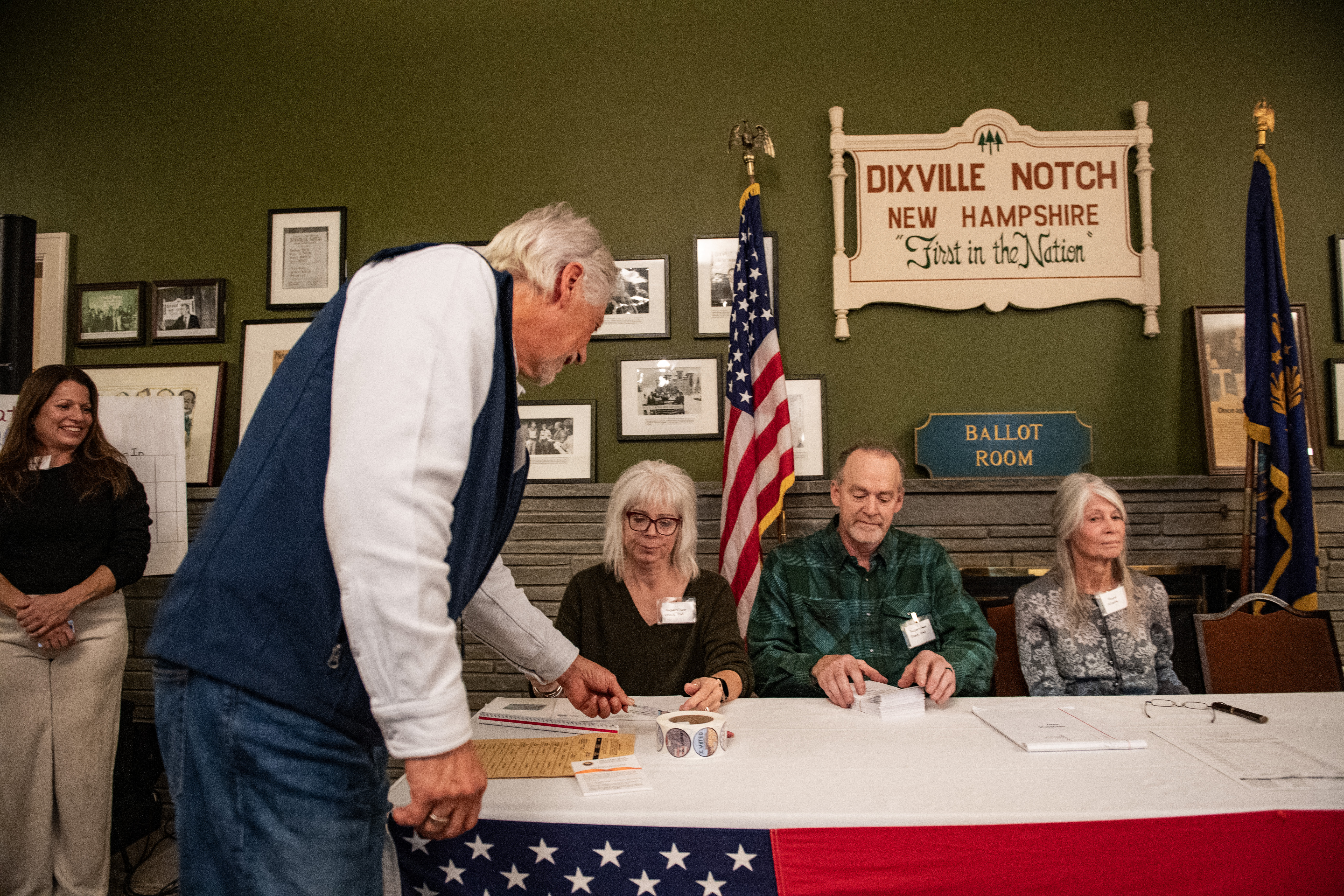 A resident of Dixville Notch shows their ID as they check in to cast their ballots in the US election at midnight in the living room of the Tillotson House at the Balsams Grand Resort, marking the first votes in the US election, in Dixville Notch, New Hampshire on November 5, 2024. The six people voting in Dixville Notch, four Republican and two undeclared, kick off Election Day at the stroke of midnight.<br />
Vice President Kamala Harris and former President Donald Trump have tied with three votes each.