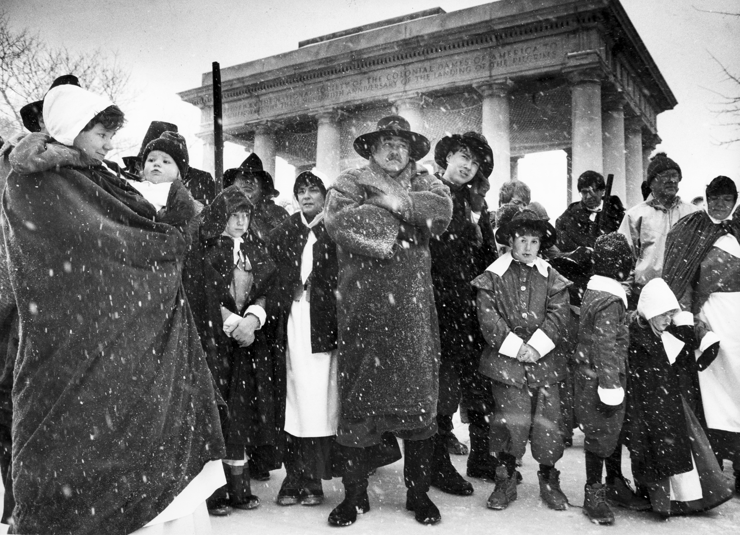 People stand near Plymouth Rock for a prayer service during the annual Thanksgiving Day Pilgrims' Progress, in which they marched to the First Parish Church in the center of Plymouth, Mass. on Nov. 23, 1989. Thousands of hot meals were served in shelters in the Boston area, and southern and central New England saw what forecasters said was the biggest Thanksgiving snowstorm since 1925.