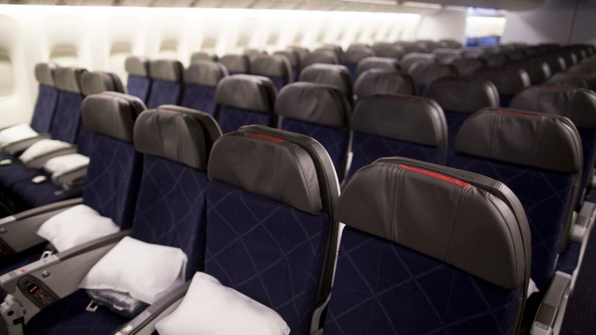 Seats in the economy class cabin on board an American Airlines Boeing Co. 777-300ER aircraft.