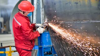 A worker grinds at a workshop of an equipment manufacturing company in Qingzhou Economic Development Zone, East China’s Shandong province, March 31, 2023.