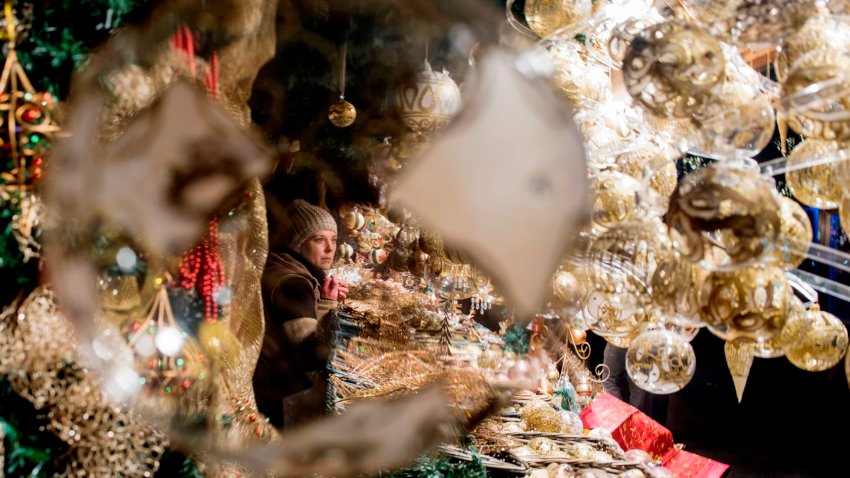 A visitor shops at a Christmas market in front of Vienna’s City Hall. 