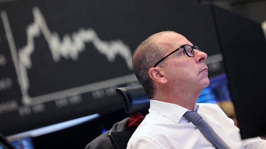 A trader works on front of a chart displaying Germany’s share index DAX at the stock exchange in Frankfurt am Main, western Germany, on December 3, 2024. Germany’s blue-chip DAX stock index jumped above 20,000 points for the first time following gains on US and Asian markets, defying multiple headwinds battering Europe’s biggest economy. The DAX groups the 40 largest publicly-traded companies on the Frankfurt Stock Exchange. (Photo by Daniel ROLAND / AFP) (Photo by DANIEL ROLAND/AFP via Getty Images)