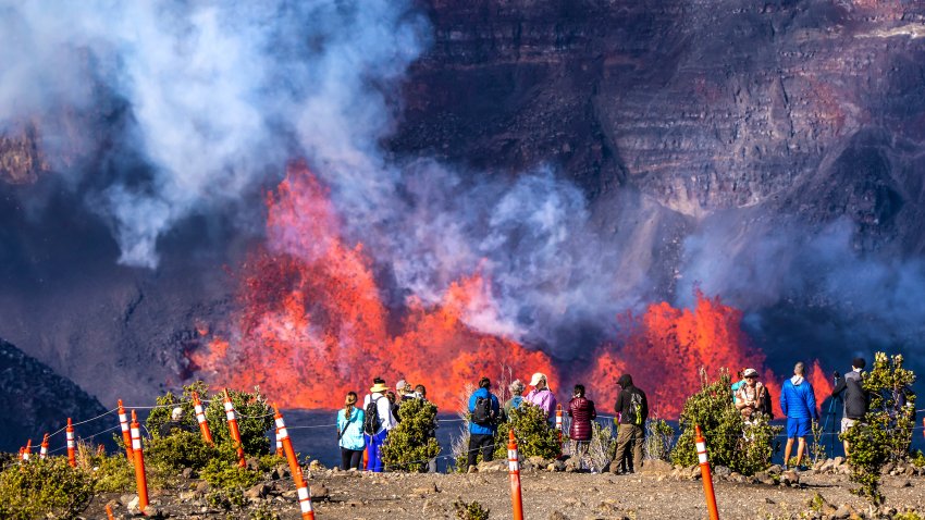 In this photo provided by the National Park Service, people watch as an eruption takes place on the summit of the Kilauea volcano in Hawaii, Monday, Dec. 23, 2024.