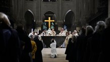 TOPSHOT - A member of the clergy kneels down as the Archbishop of Paris Laurent Ulrich (C) leads prayers for the consecration of the new main altar, designed by French artist and designer Guillaume Bardet which replaces the old one that was destroyed in 2019, during a mass at the Notre-Dame de Paris cathedral, in Paris on December 8, 2024. Newly restored Notre Dame cathedral is set to hold its first service for the public on December 8, 2024 after a historic re-opening ceremony that saw firefighters, builders and artists celebrated for their work saving the 12th-century masterpiece. The beloved Paris monument nearly burned down in 2019, but has been renovated inside and fitted with a new roof and spire during a frenzied reconstruction effort since then. (Photo by JULIEN DE ROSA / AFP) / RESTRICTED TO EDITORIAL USE - MANDATORY MENTION OF THE ARTIST UPON PUBLICATION - TO ILLUSTRATE THE EVENT AS SPECIFIED IN THE CAPTION (Photo by JULIEN DE ROSA/AFP via Getty Images)