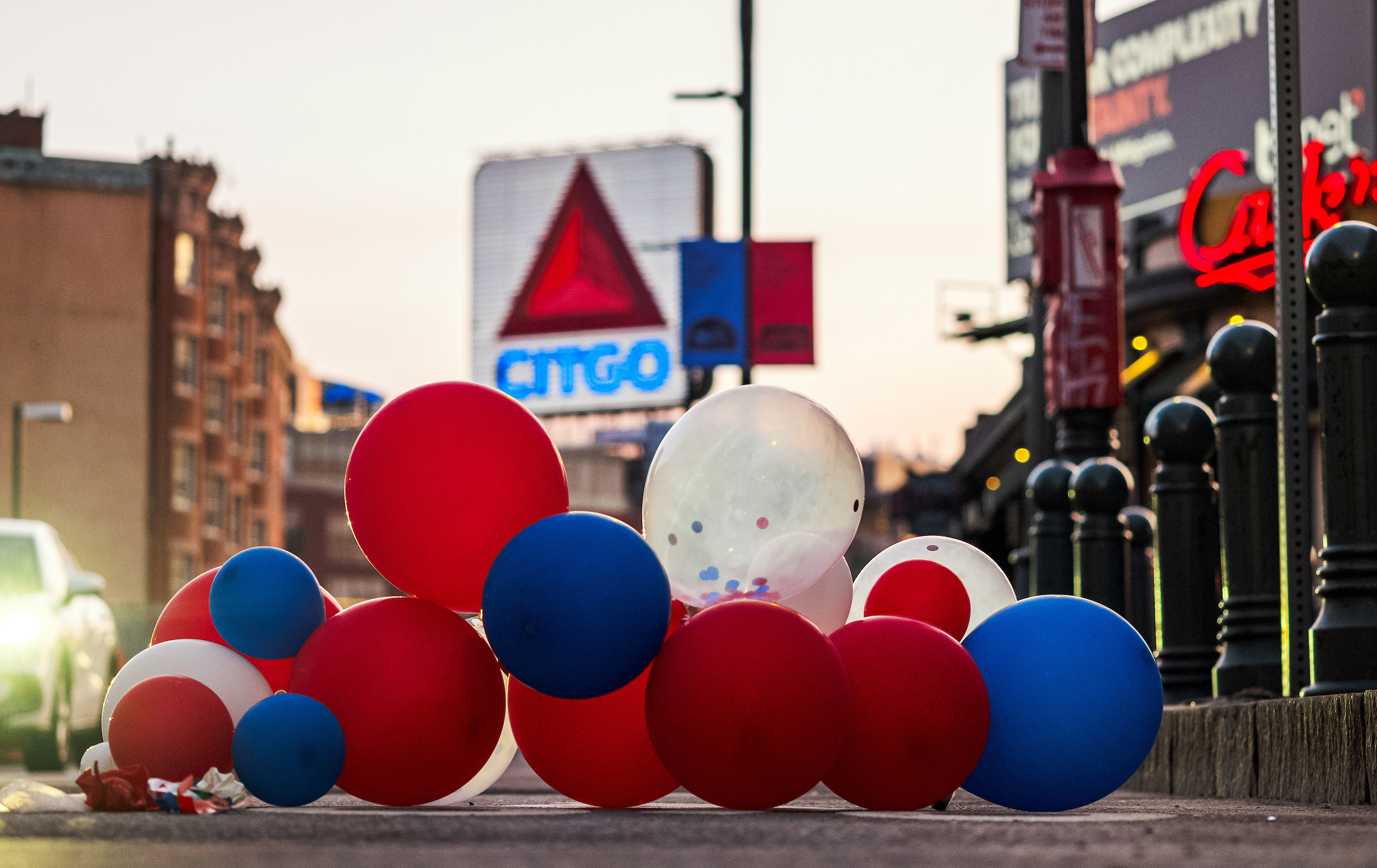 April 10, 2024: Balloons left over from the Red Sox home opener, a 7–1 loss to Baltimore, the day before blow in the wind and settle on Brookline Avenue outside of Fenway Park.