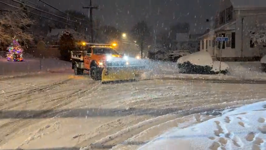 A plow drives through a snowy street in Norwood, Massachusetts, on Friday, Dec. 20, 2024.