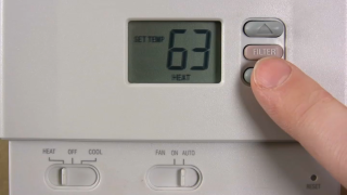 A thermostat set to 63 degrees