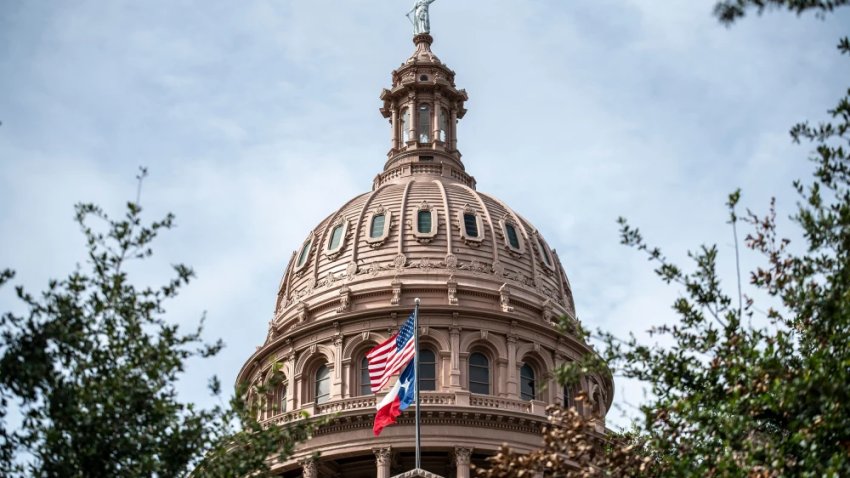 The U.S. and Texas state flags fly outside the state Capitol building, in Austin, Texas, on July 12, 2021.