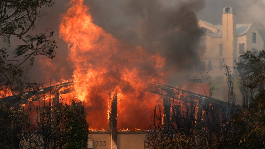 The Palisades Fire ravages a neighborhood amid high winds in the Pacific Palisades neighborhood of Los Angeles, Wednesday, Jan. 8, 2025.