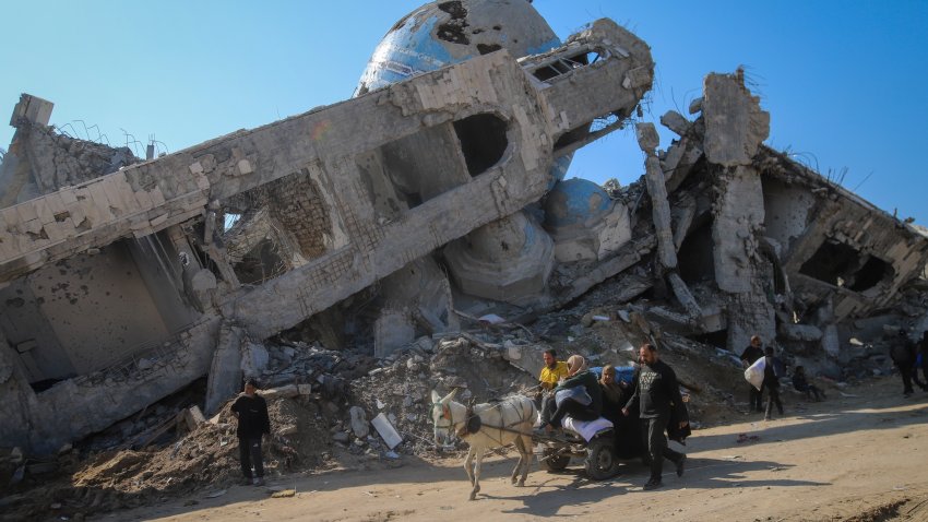 A family rides in a horse-drawn cart past a destroyed mosque in Beit Lahia, northern Gaza Strip, Wednesday, Jan. 29, 2025, after Israel began allowing hundreds of thousands of Palestinians to return to the heavily damaged area last Monday.