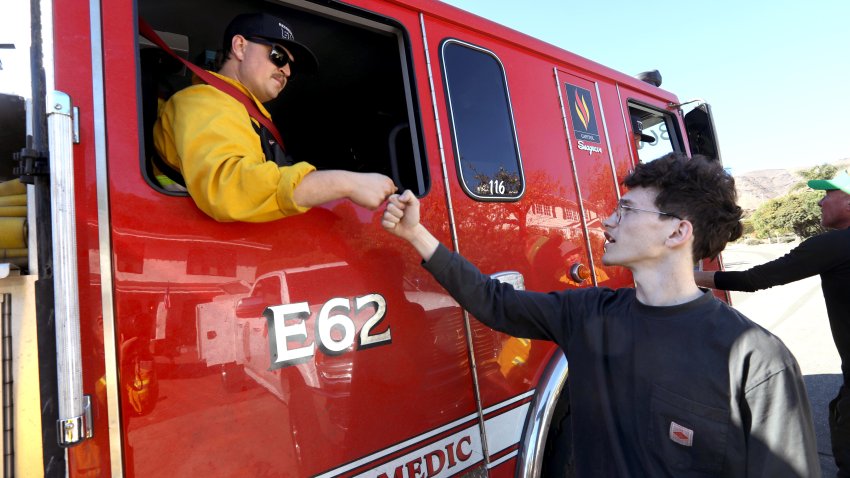 Colton Foster, 21, gives Redondo Beach firefighter Declan O'Brien a fist bump of thanks in the Pacific View Estates neighborhood, near the Getty Villa, in Palisades on January 14, 2025.