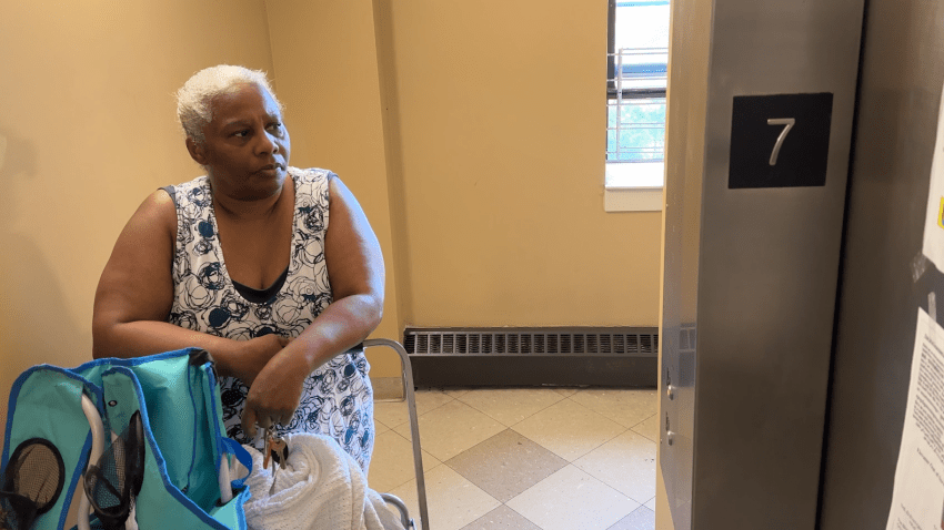 Sheila Thompson waits for an elevator at the Ruth Barkley Apartments in Boston's South End.