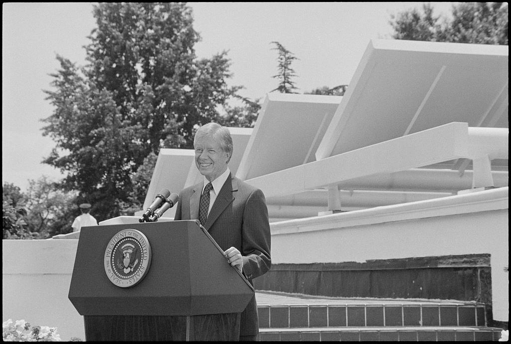 President Jimmy Carter speaks in front of the solar panels installed on the roof of the West Wing of the White House as he announced his solar energy policy on June 20, 1979.