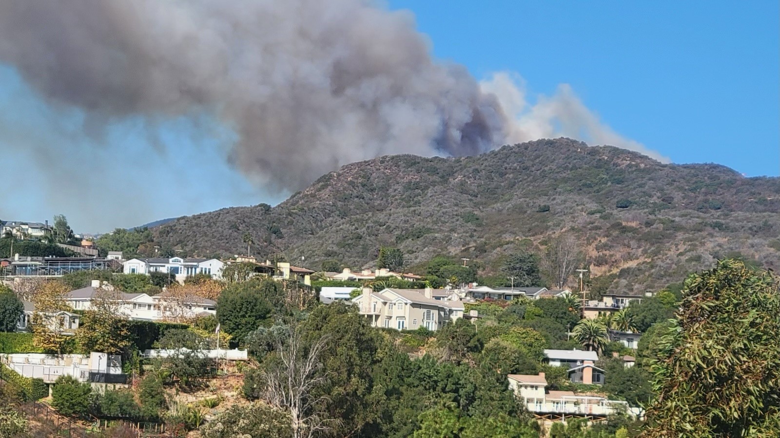 Smoke rises over a hill in the Pacific Palisades area.