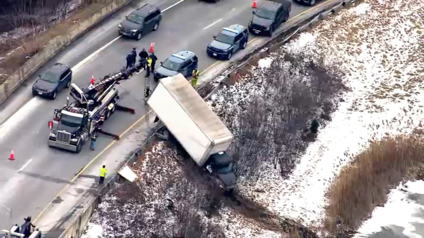 A crashed truck being hauled back onto a ramp connecting the Massachusetts Turnpike and I-95 in Weston on Monday, Jan. 13, 2025.