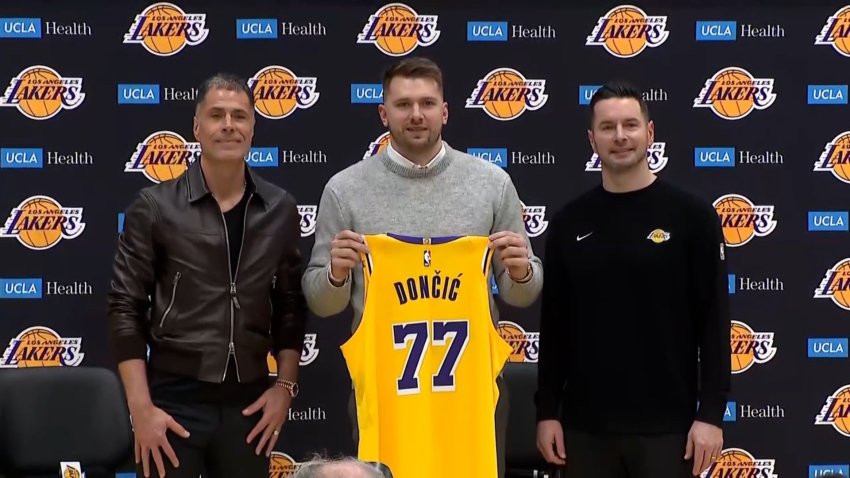 Luka Dončić hold up Lakers jersey