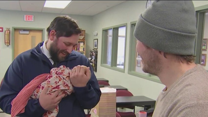 Jonathan DuBois holding Annalise McNally, the 1-month-old baby he helped deliver, at their reunion in Tuftonboro, New Hampshire, on Tuesday, Feb. 4, 2025.