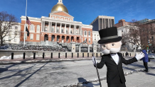 Mr. Monopoly stands in front of the Massachusetts State House.