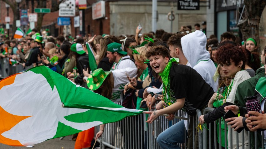 People wave flags and cheer on parade marchers during the annual St. Patrick’s Day & Evacuation Day Parade in Boston, Massachusetts on March 16, 2025. Evacuation Day commemorates the evacuation of British forces from the city of Boston, early in the American Revolutionary War. (Photo by Joseph Prezioso / AFP) (Photo by JOSEPH PREZIOSO/AFP via Getty Images)